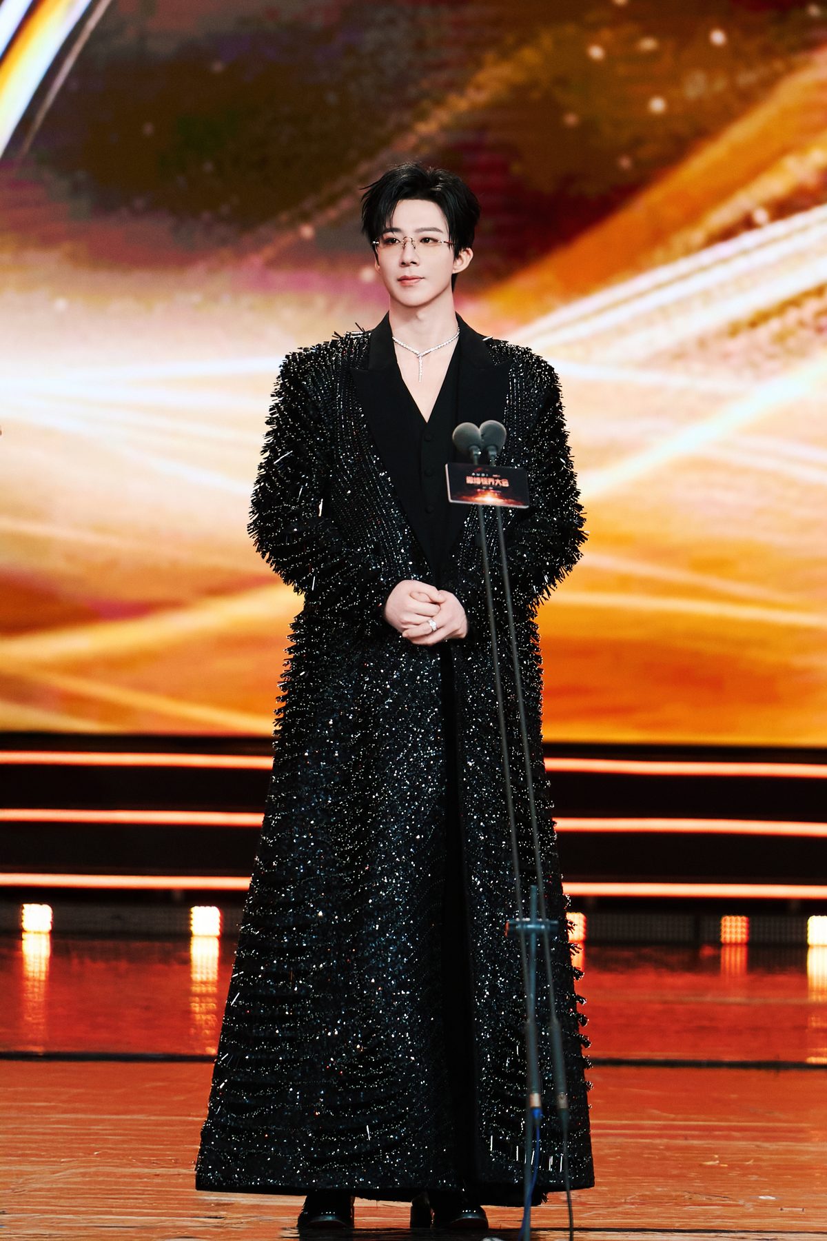 Liu Yuning wearing a fringed sequin coat on an awards show stage, full outfit
