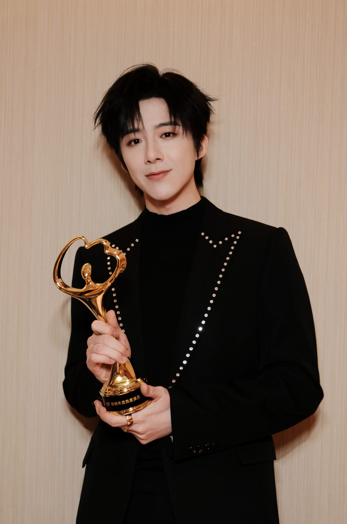 Liu Yuning in a crystal-embellished suit holding an award trophy