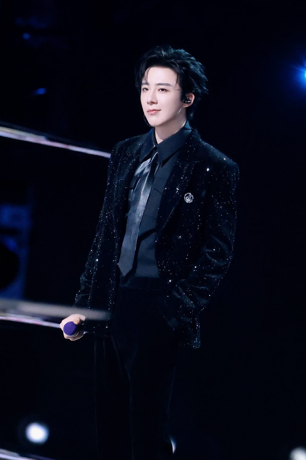 Liu Yuning performing live on stage in a black sequin outfit